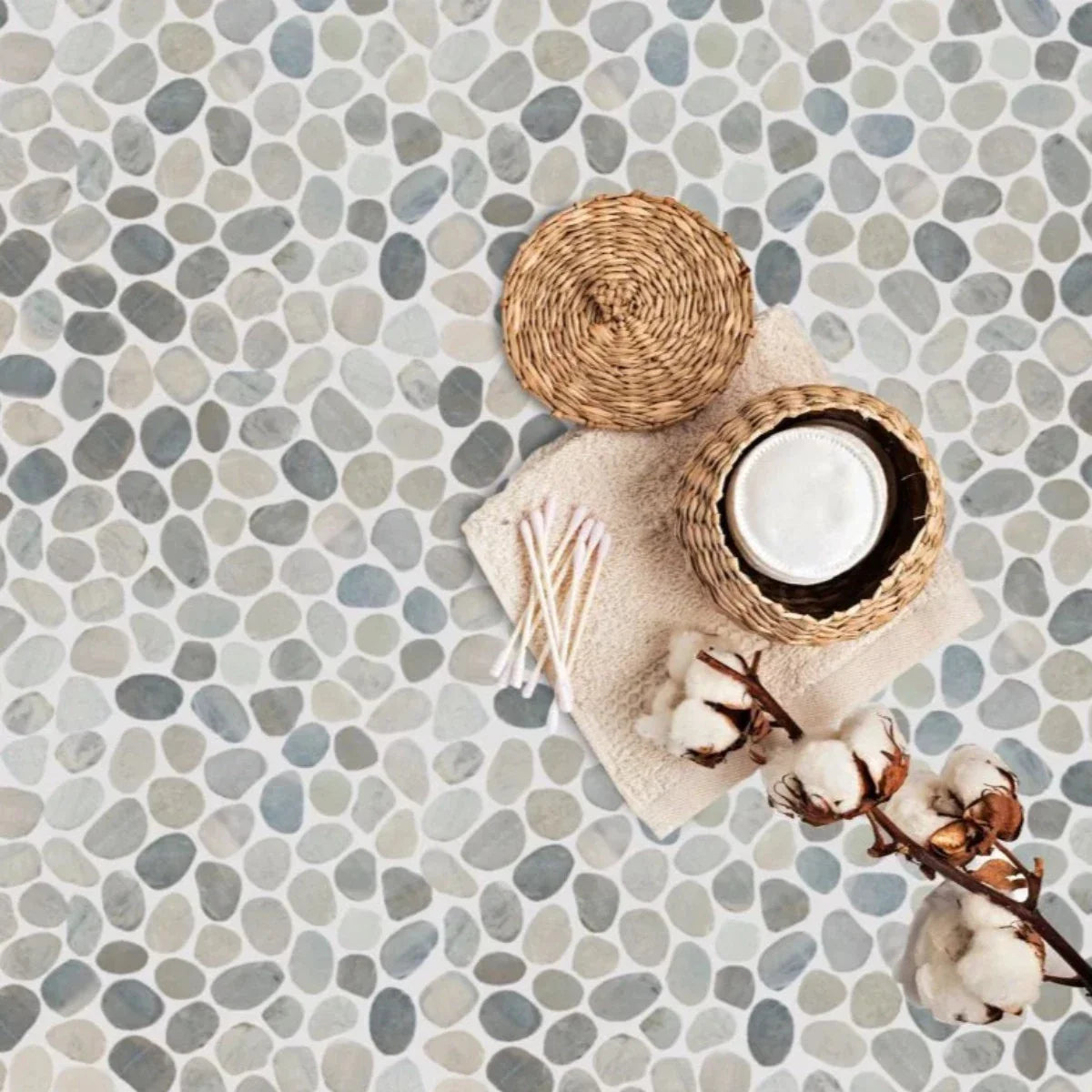 Pale sliced pebble tile flooring with cotton swabs and a cotton plant on top of the floor