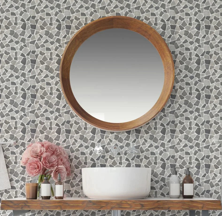 Stone Grey tile on wall with round mirror and bathroom sink/countertop infront of it